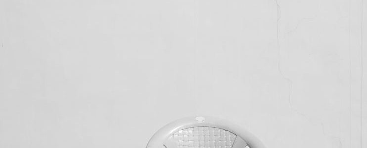 a plastic chair near the white wall